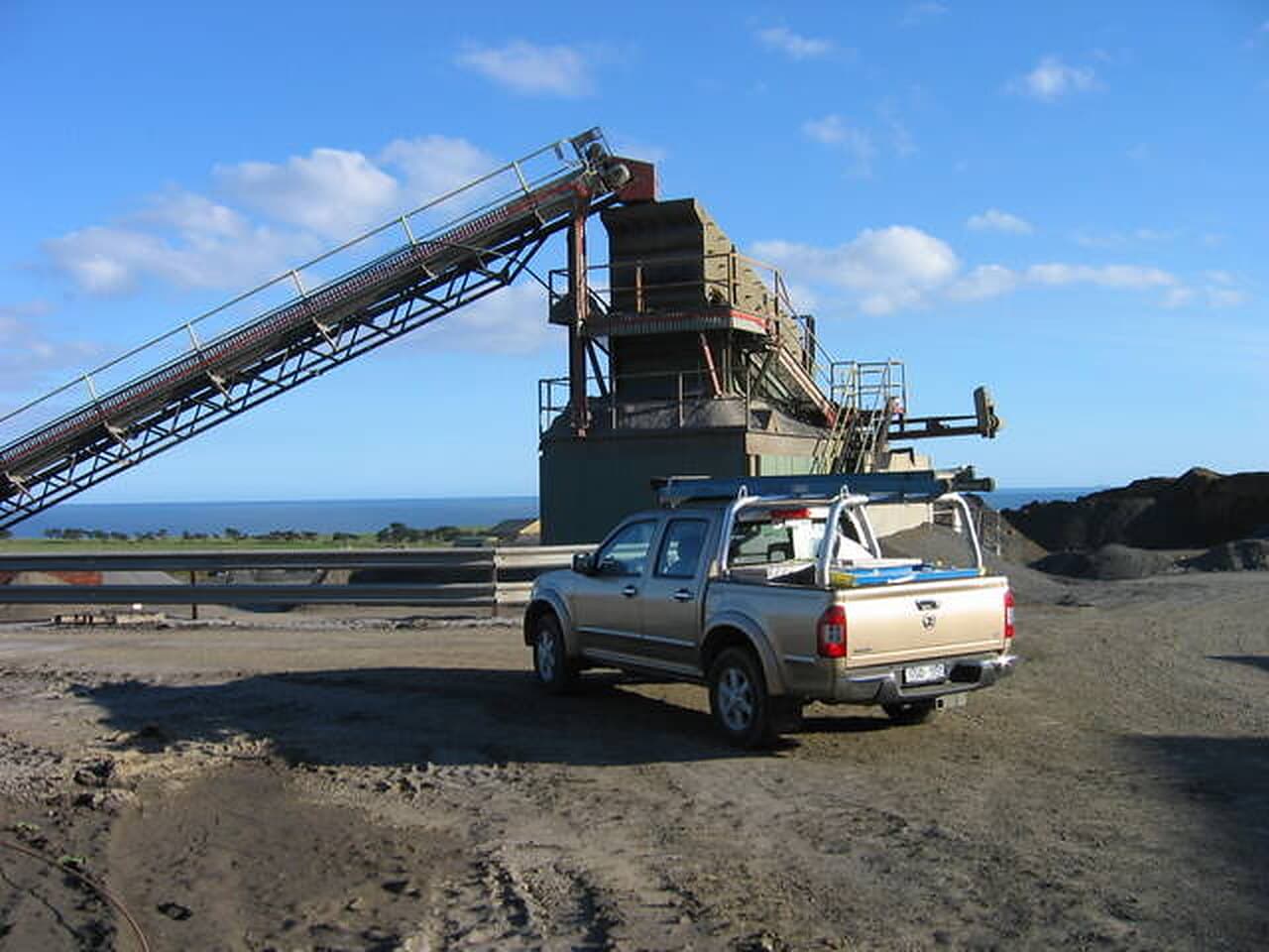 Quarry processing plant with conveyor and screening tower on the Victorian coast
